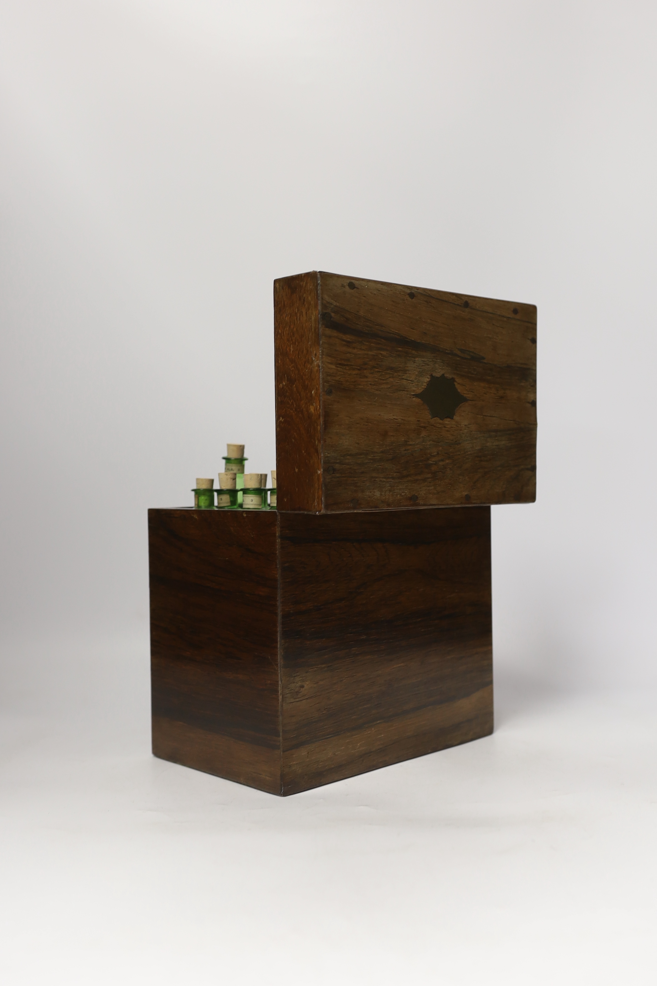 A Victorian rosewood homeopathic apothecary box, by Leath and Ross, two segmented drawers below a top opening section, containing a number of labelled chemists bottles, 21cm high, 20cm wide, 13.5cm deep